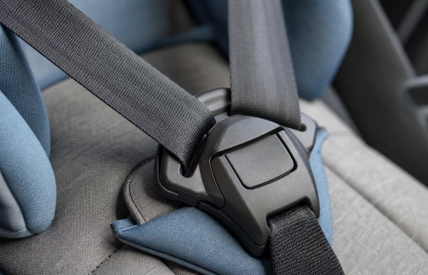 Szülő ellenőrzi az ISOFIX bekattanását egy autósülésnél, kézzel megrángatva az ülést